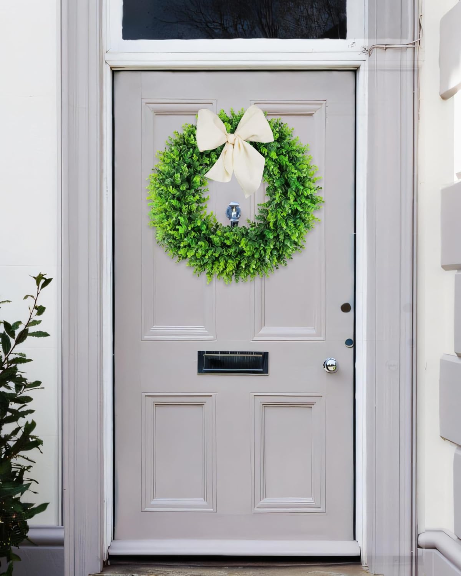 A 24 inch year round greenery boxwood wreath is hanging on the front door.