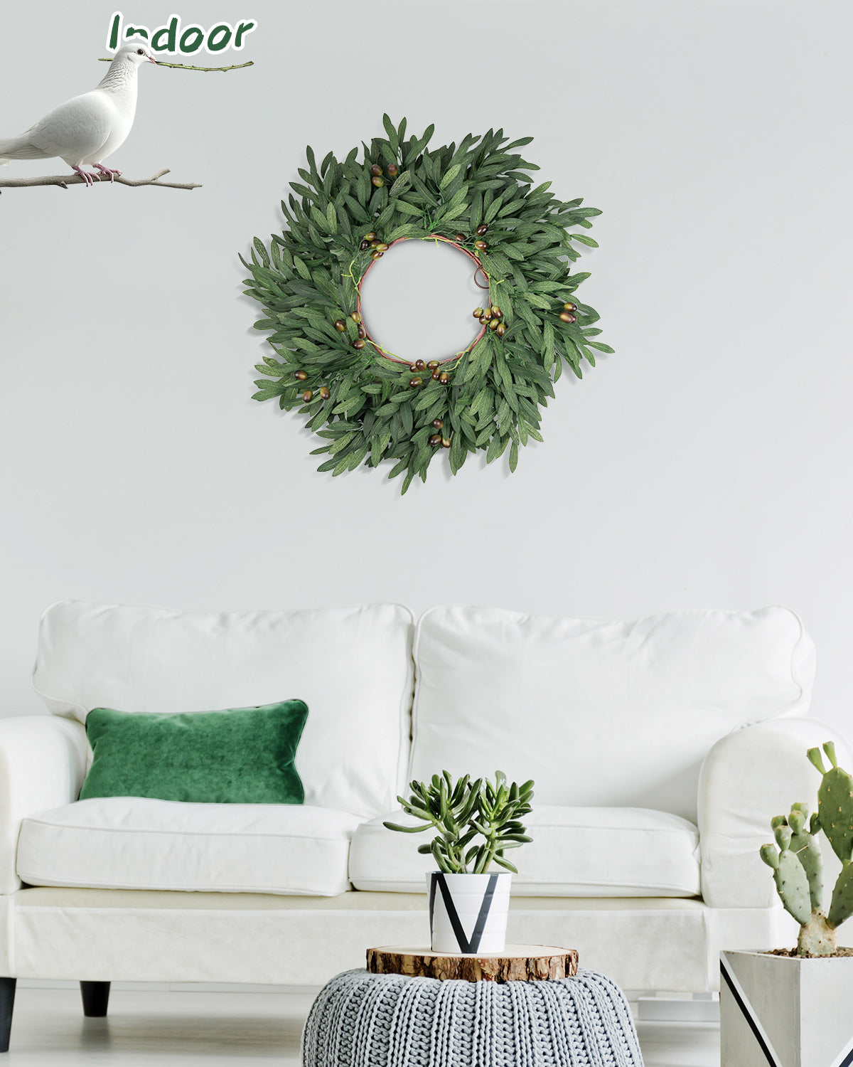 The 24 inch year round olive branch wreath is hanging on the wall in the living room.
