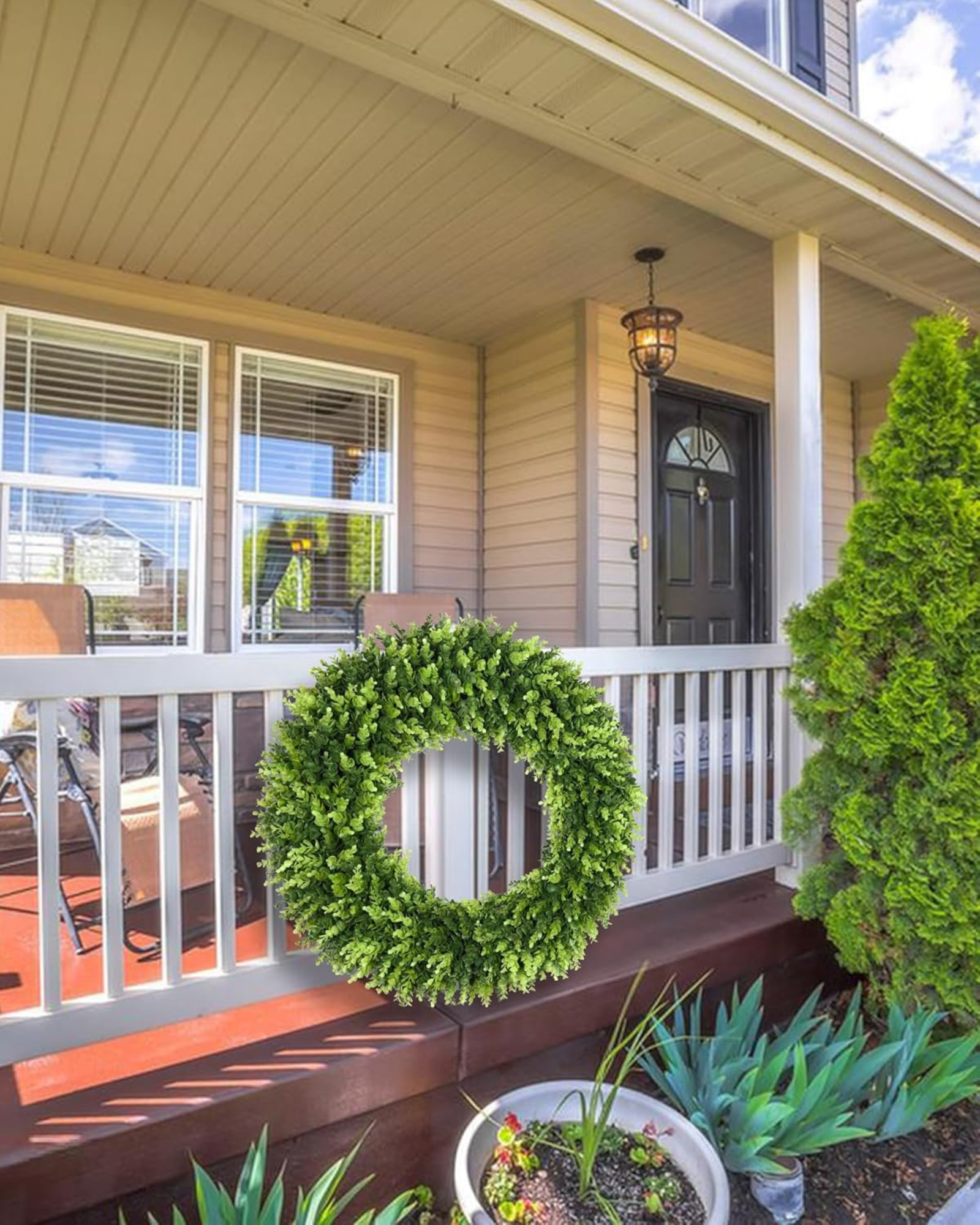 32 inch year round large boxwood wreath is hanging on the fence.