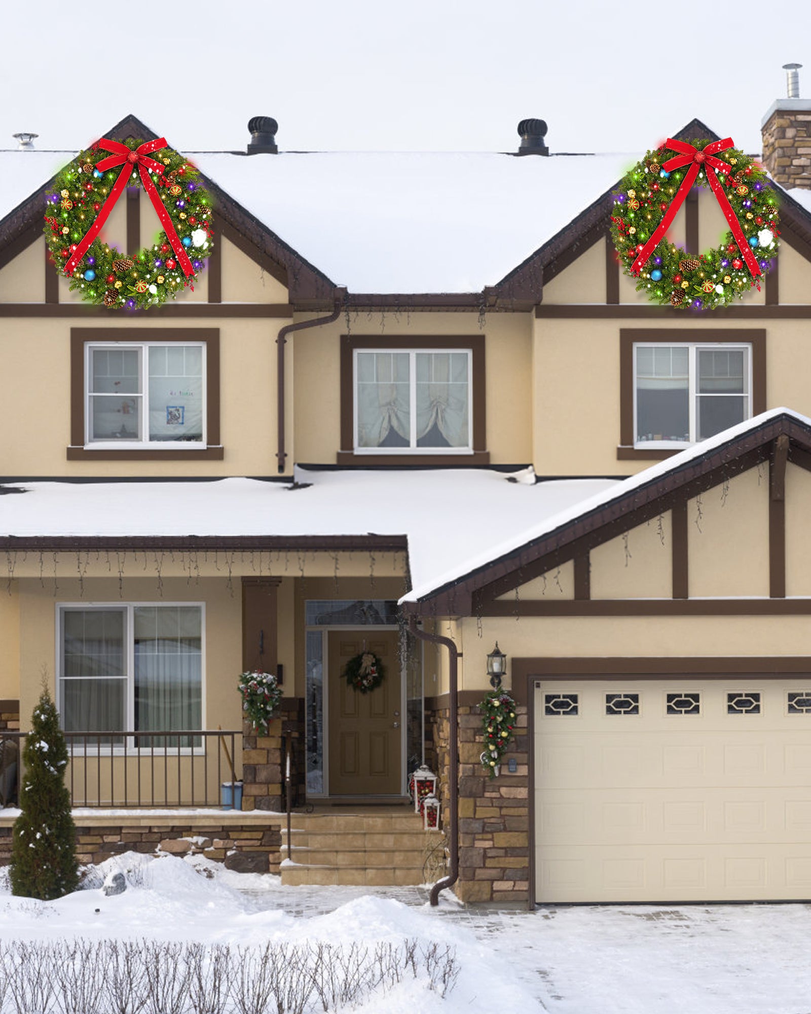 Two 48 inch prelit large outdoor christmas wreaths are hanging on the front door.