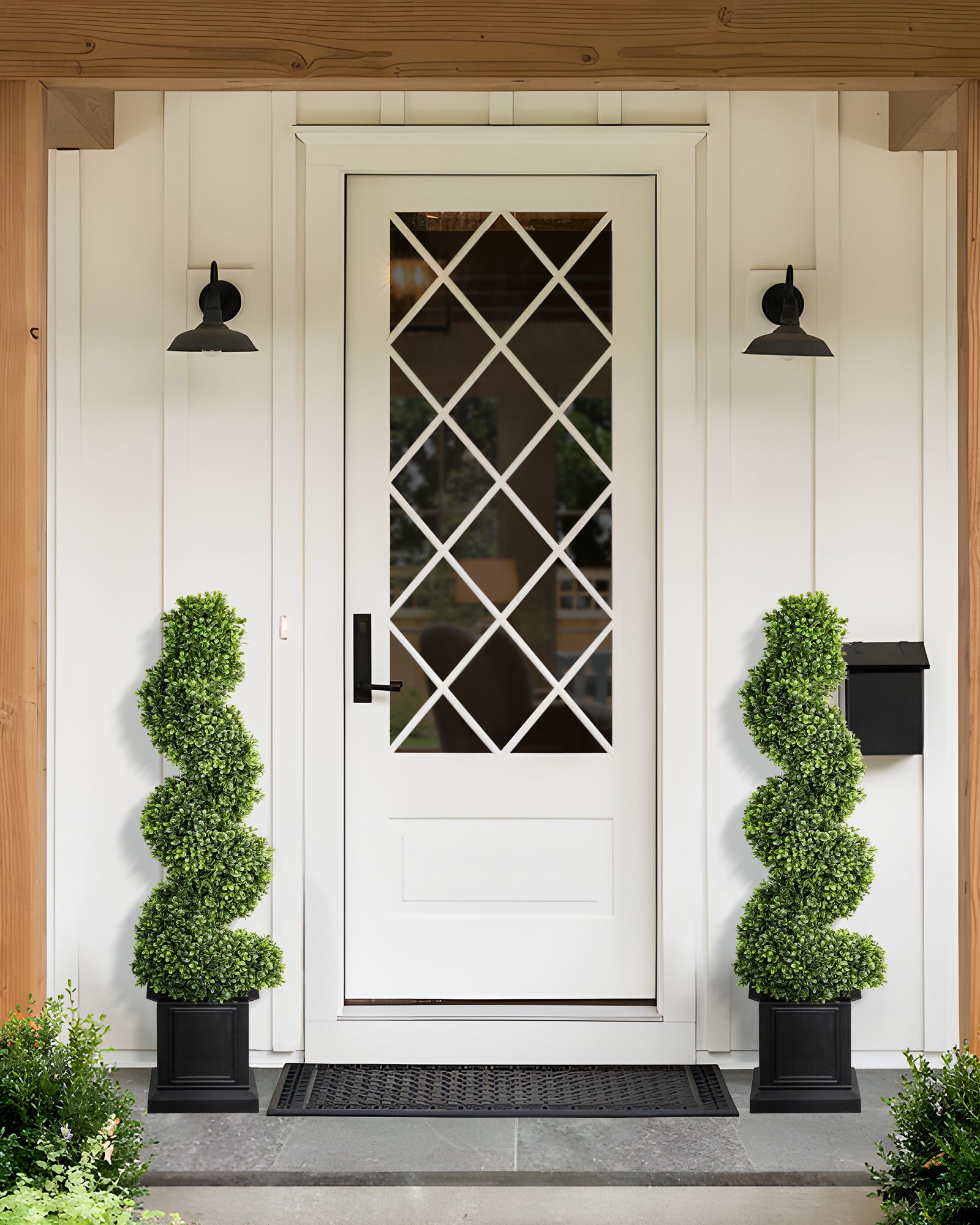 4ft spiral artificial boxwood topiary trees are standing in the front porch.